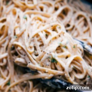 Fettuccine Alfredo garnished with fresh parsley.