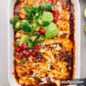 Tender Slow-Cooked Shredded Beef Enchiladas 4 A close-up shot of two shredded beef enchiladas, perfectly rolled and baked in a rich red sauce, topped with melted cheese and fresh cilantro, promising a delicious and comforting meal.