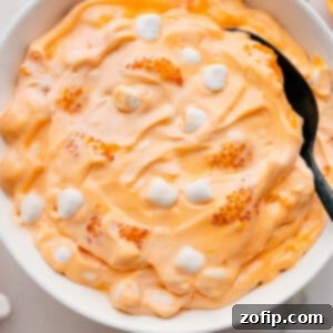 Dreamsicle Fluff 3 Orange Fluff Salad in a large serving bowl, showcasing its fluffy texture and vibrant orange color.