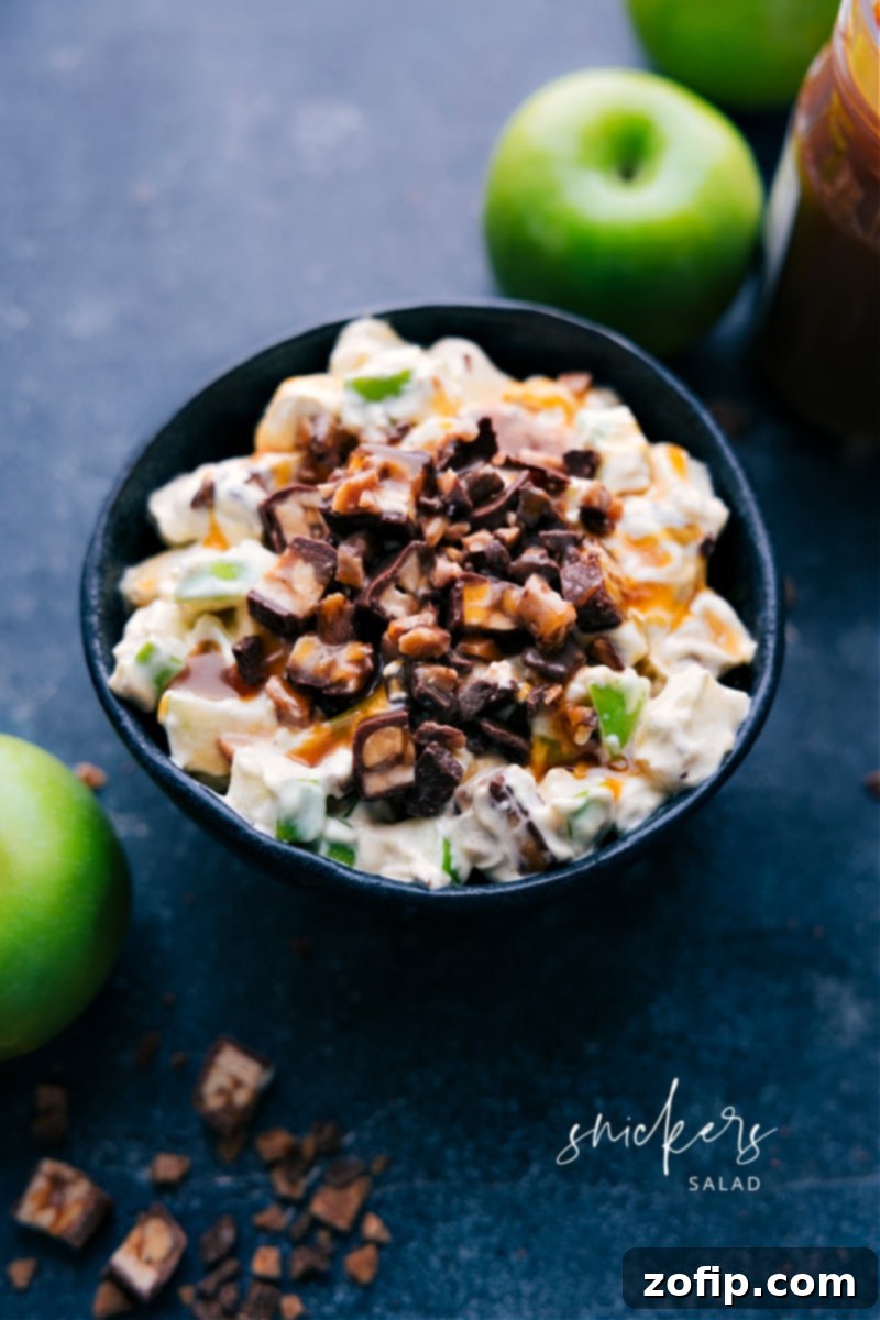 Delicious Snickers Salad with diced apples and candy bars in a creamy topping