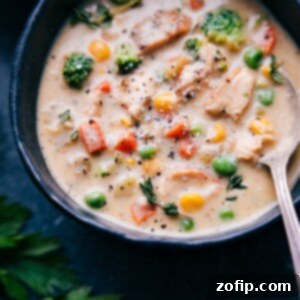 A close-up shot of a bowl of Creamy Chicken Soup with fresh parsley garnish.