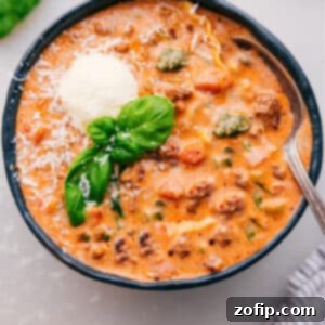The Only Lasagna Soup You Will Ever Need 3 A comforting bowl of creamy lasagna soup, garnished with fresh basil and grated Parmesan cheese.
