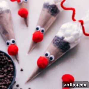 A finished Reindeer Hot Chocolate cone with googly eyes, a red pom pom nose, and pipe cleaner antlers.