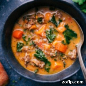 A delicious bowl of Healthy Zuppa Toscana soup, garnished with fresh greens.