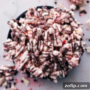 Finished Peppermint Popcorn in a bowl, showing the white chocolate, crushed peppermint, and dark chocolate drizzle