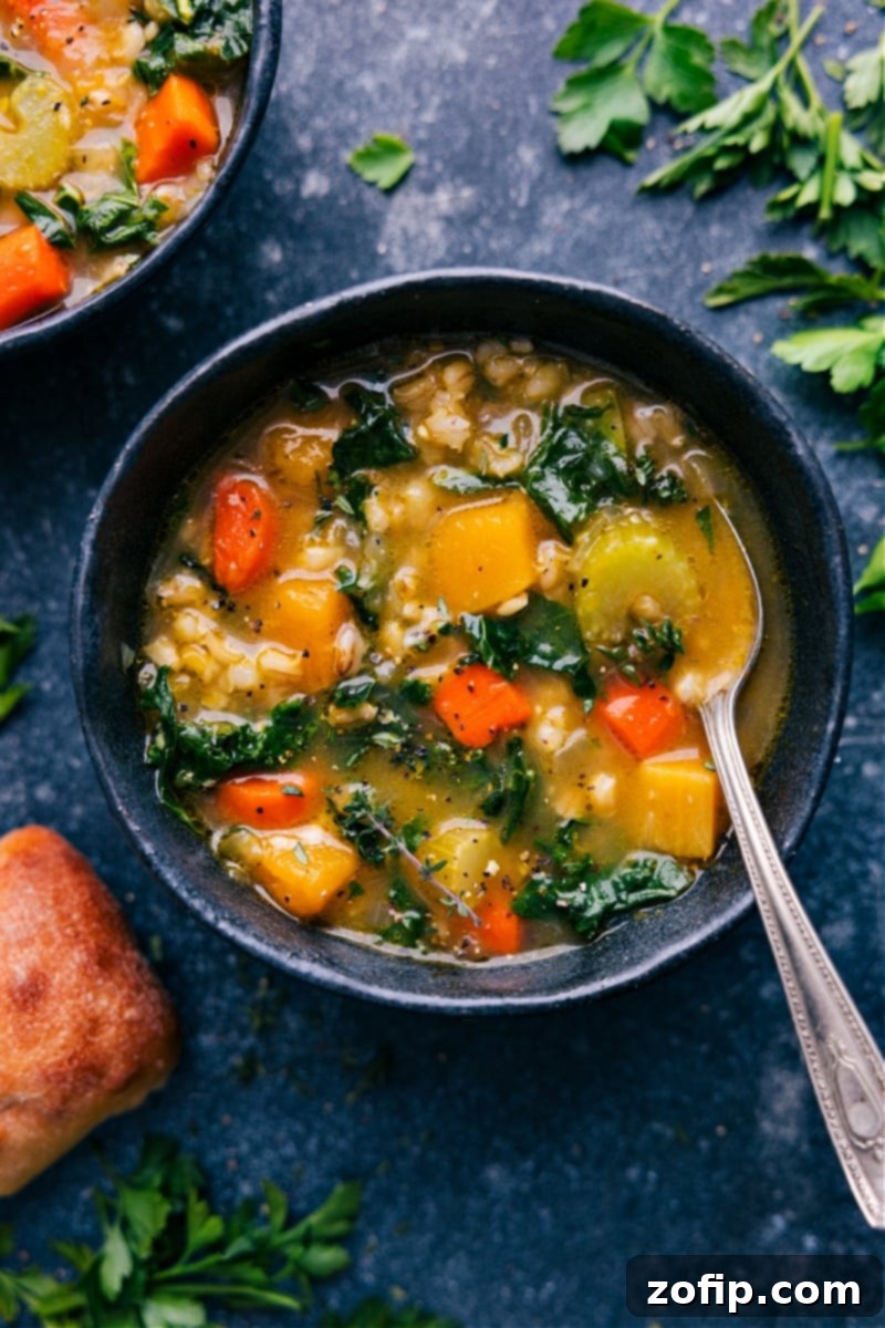 Nutritious & Satiating One-Pot Vegetable Barley Soup – Loaded with Veggies, Rich Broth & Tender Barley. Delicious, Healthy & Comforting! #dinner #quick #easy #simple #familfriendly #comfortfood #winterrecipes #barley #soup A vibrant overhead shot of a steaming bowl of one-pot Vegetable Barley Soup, garnished with fresh herbs and a dash of Parmesan, ready to be served with crusty bread.
