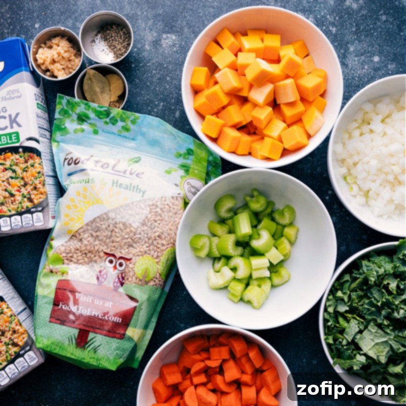 This nutritious and satiating one-pot Barley Soup is loaded up with tons of veggies, a rich seasoned broth, and tender barley. Top your bowl with some fresh herbs and a sprinkle of Parmesan cheese-- and then grab some crusty bread for dunking! Recipe via chelseasmessyapron #dinner #quick #easy #simple #familfriendly #comfortfood #winterrecipes #barley #soup Close-up ingredient shot displaying all the fresh vegetables, herbs, and pearled barley neatly arranged, ready for making the Barley Soup.