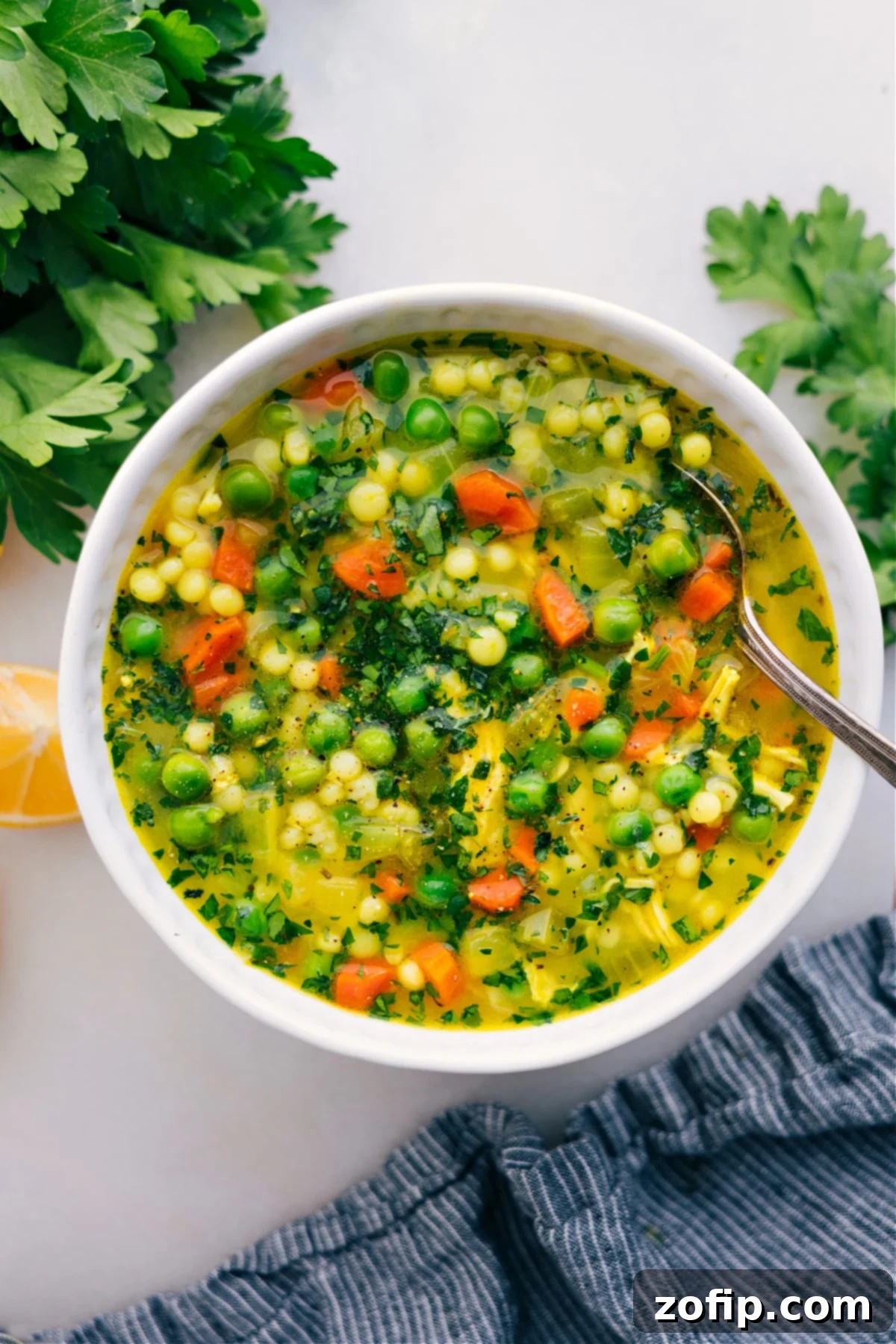 Cold-Buster Chicken Couscous Soup Recipe A steaming bowl of Cold Buster Chicken Couscous Soup, garnished with fresh parsley, highlighting its rich broth, tender chicken, and vibrant vegetables. This recipe is perfect for a comforting meal.