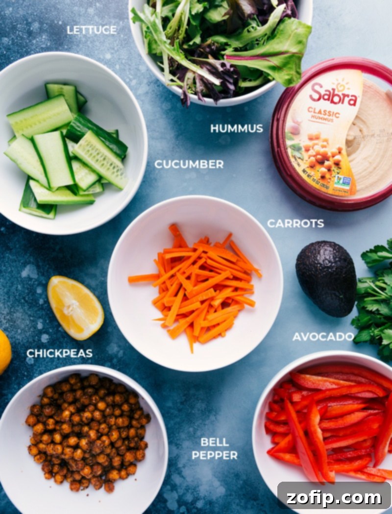 Ingredients laid out for making Hummus Wraps: chickpeas, hummus, various fresh vegetables, and spices.