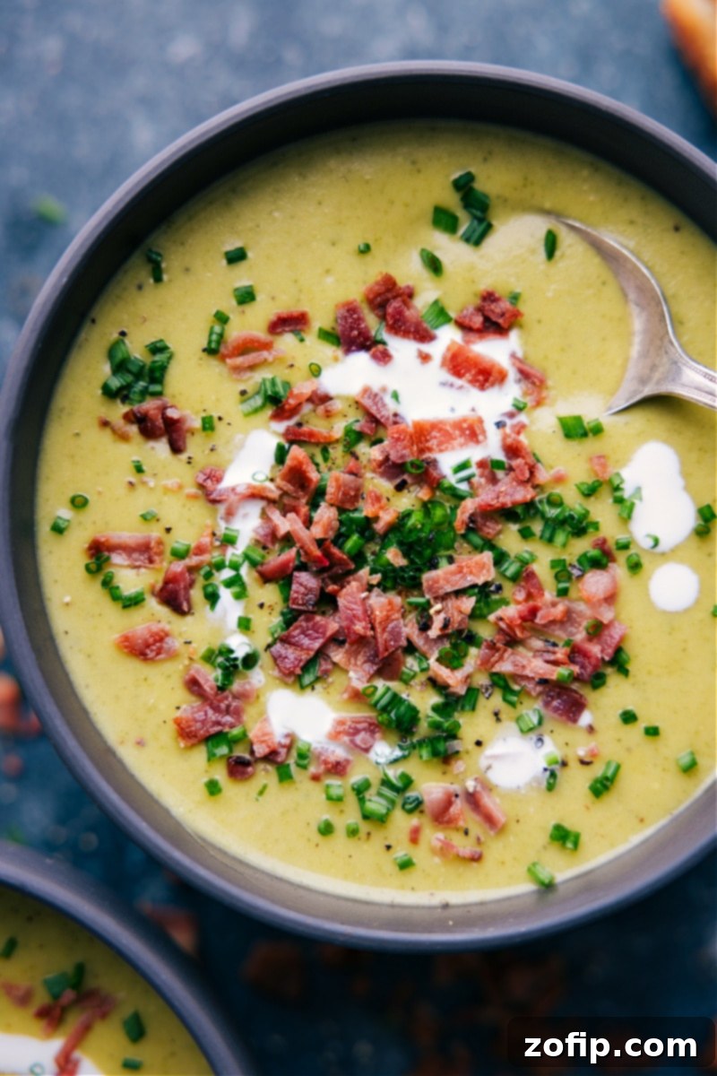 Creamy Broccoli Delight 2 Overhead shot of a steaming bowl of creamy cheesy broccoli soup, garnished with fresh herbs.
