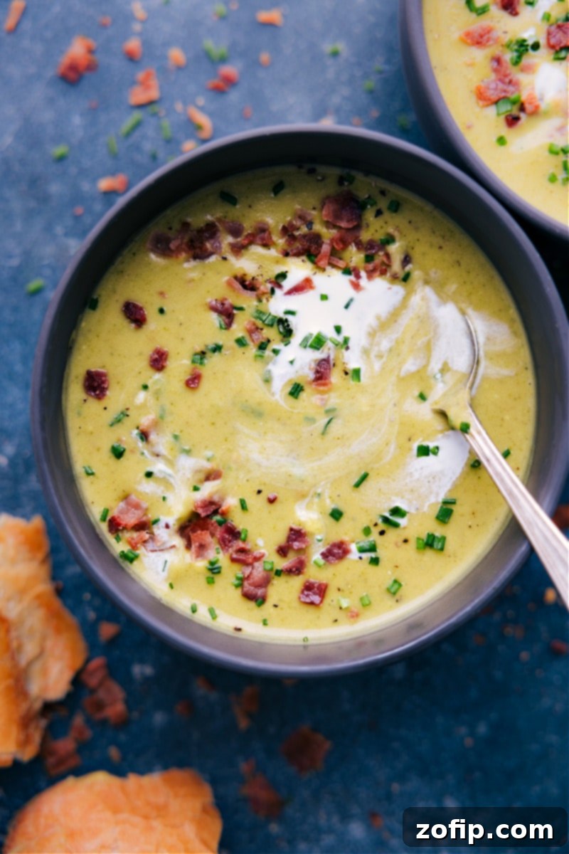 Creamy Broccoli Delight 7 Overhead shot of a person enjoying a bowl of creamy broccoli soup with a piece of crusty bread for dipping.