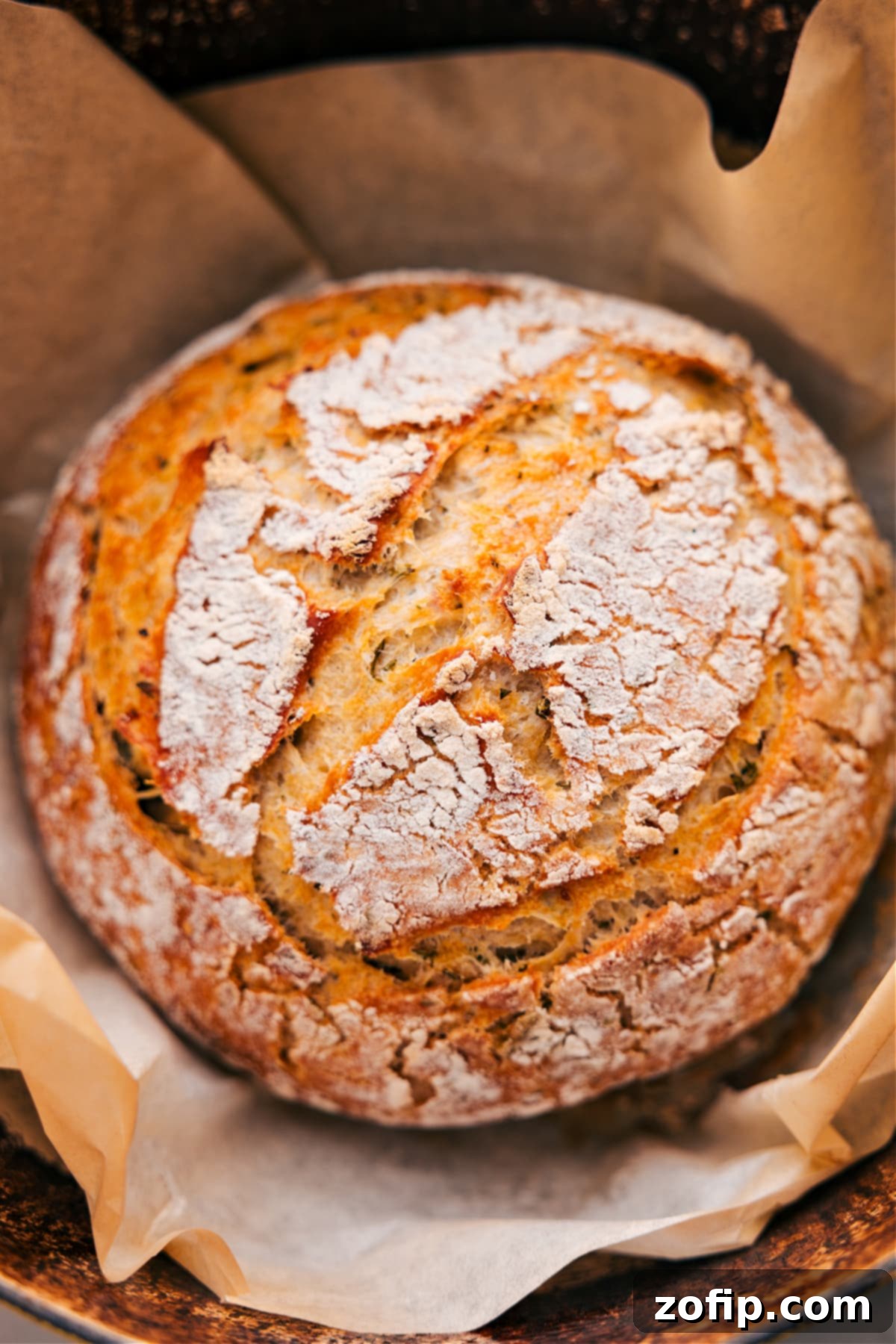 A glorious loaf of No-Knead Herb Bread, fresh out of the oven, still in its cast iron pot, showcasing its golden crust.