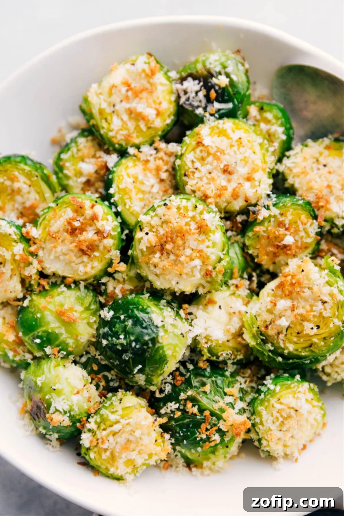 A large serving dish overflowing with perfectly golden and glossy roasted Brussels sprouts, ready for guests.