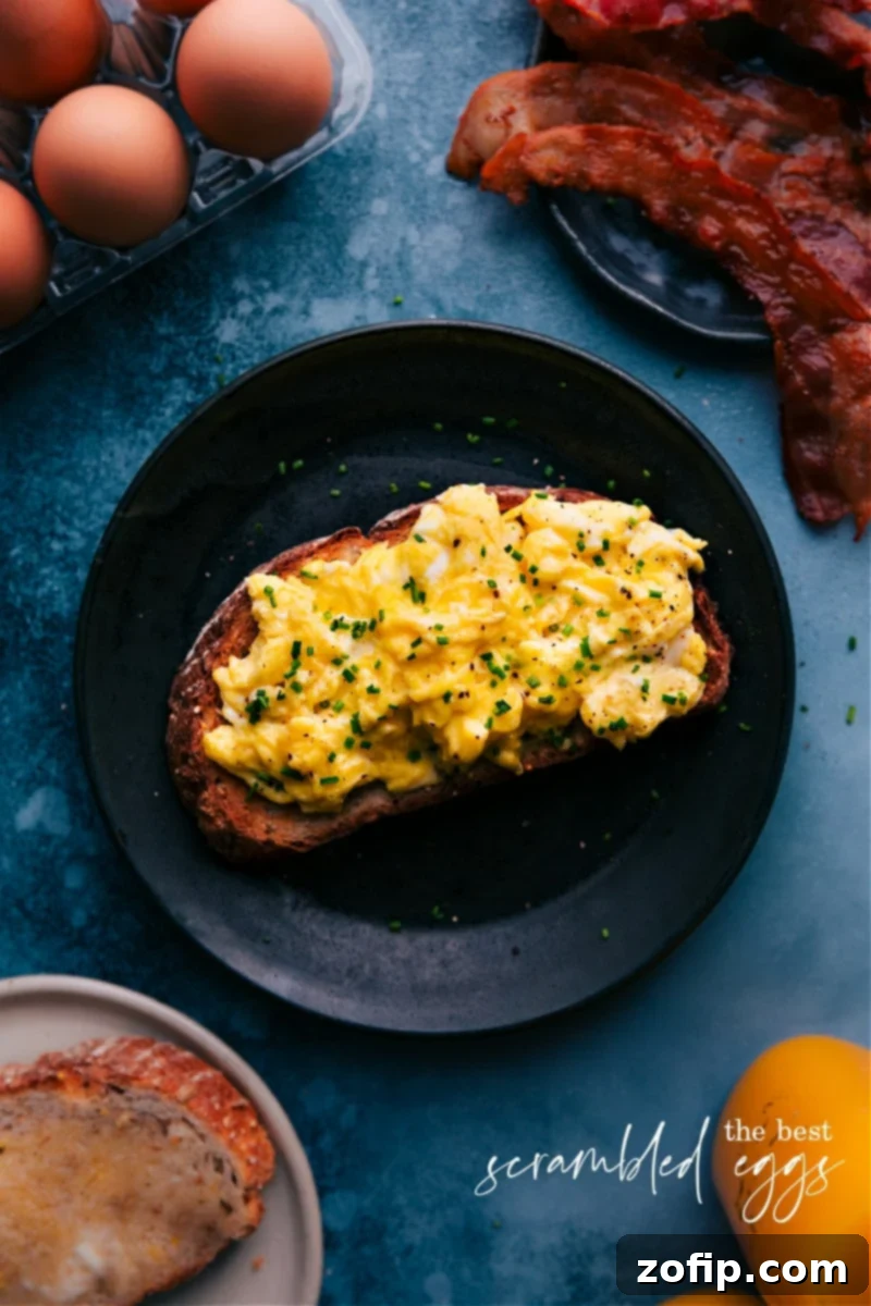 Overhead image of perfectly cooked creamy scrambled eggs, garnished with fresh chives, ready to be served for a delightful breakfast