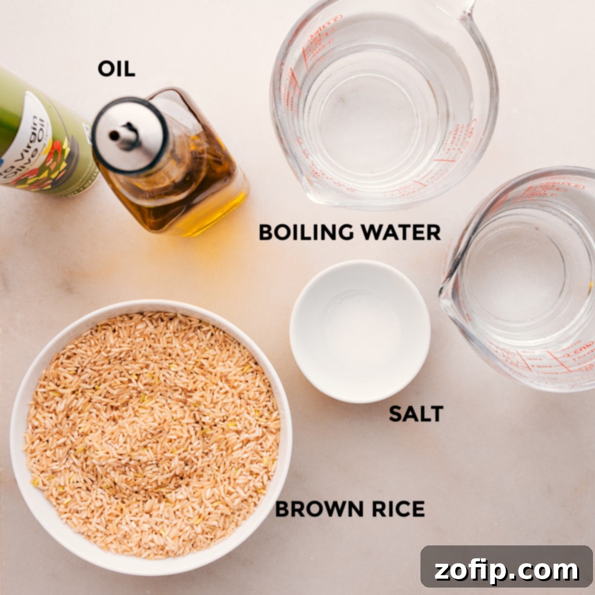 Essential ingredients for baking brown rice: long-grain brown rice, salt, olive oil, and boiling water, arranged for easy assembly.