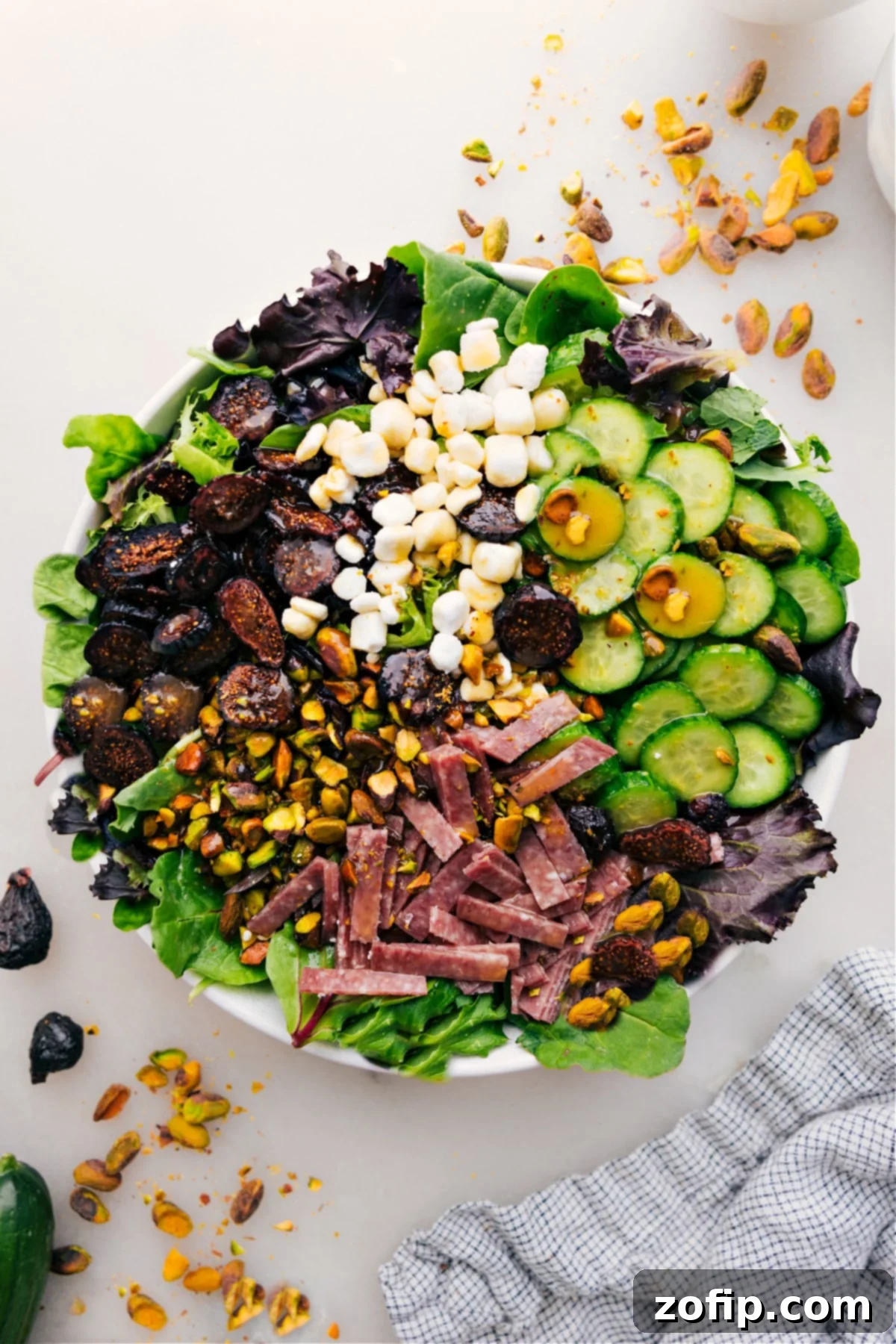 A vibrant Arugula Salad, beautifully arranged with delicious toppings, ready to be tossed and enjoyed.