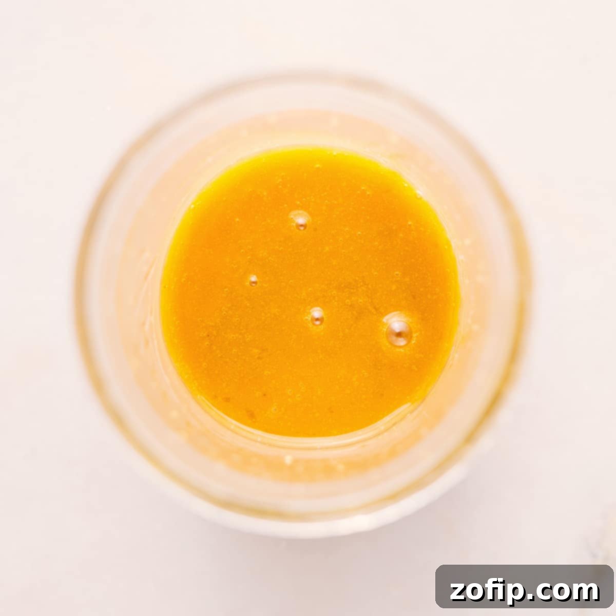 Quick And Simple White Balsamic Vinaigrette Recipe A glass mason jar filled with freshly mixed White Balsamic Vinaigrette, showcasing its smooth, emulsified texture, ready for serving.