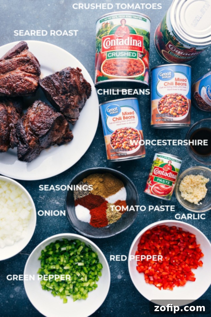 A vibrant array of fresh ingredients for Chili Con Carne, including beef chuck roast, bell peppers, onions, cans of crushed tomatoes and chili beans, and various spices.