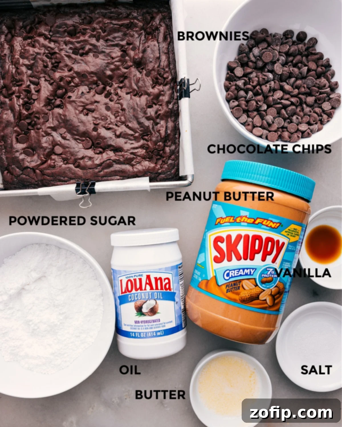 An array of fresh ingredients including brownie mix, chocolate chips, creamy peanut butter, sugar, vanilla extract, oil, and butter, neatly laid out for making the best Buckeye Brownies.