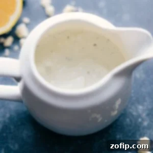 Piquant Blue Dressing 2 A bowl of creamy Blue Cheese Dressing with a spoon, garnished with chives.