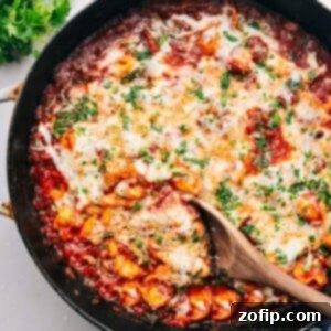 Baked tortellini fresh out of the oven, with golden cheese and visible sauce.