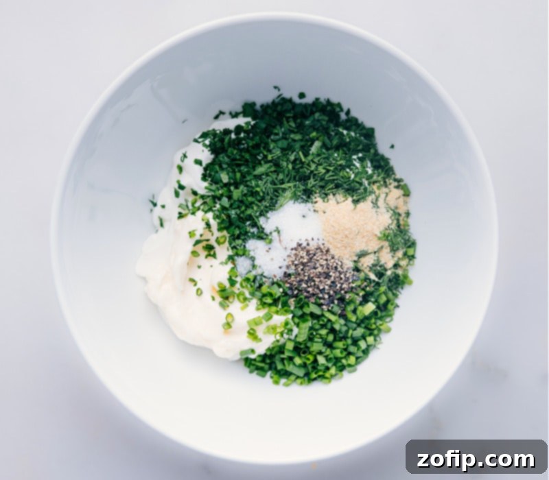 All the fresh, high-quality ingredients for the best homemade Ranch Dressing. Close-up image of all fresh ingredients for Ranch Dressing in a bowl, before mixing