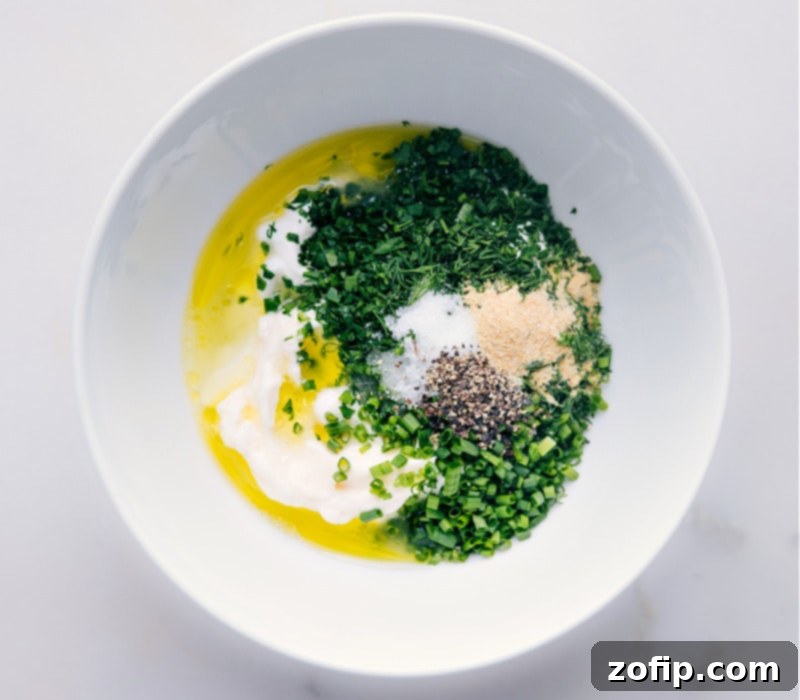 Adding premium olive oil to the Ranch Dressing mixture for richness and flavor. Process shot showing olive oil being drizzled into a bowl with other Ranch Dressing ingredients