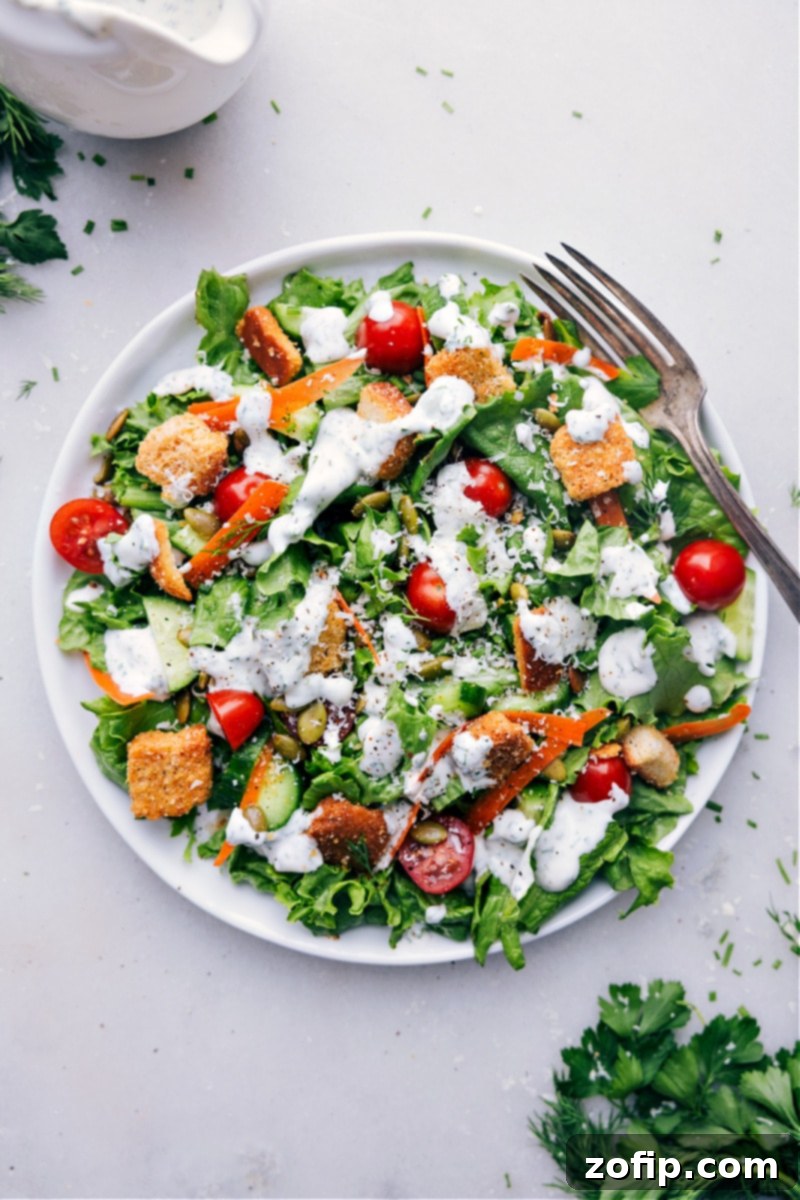 A vibrant green salad perfectly coated with the rich and creamy homemade Ranch Dressing. Image of a fresh green salad generously dressed with homemade Ranch Dressing, showcasing its creamy texture