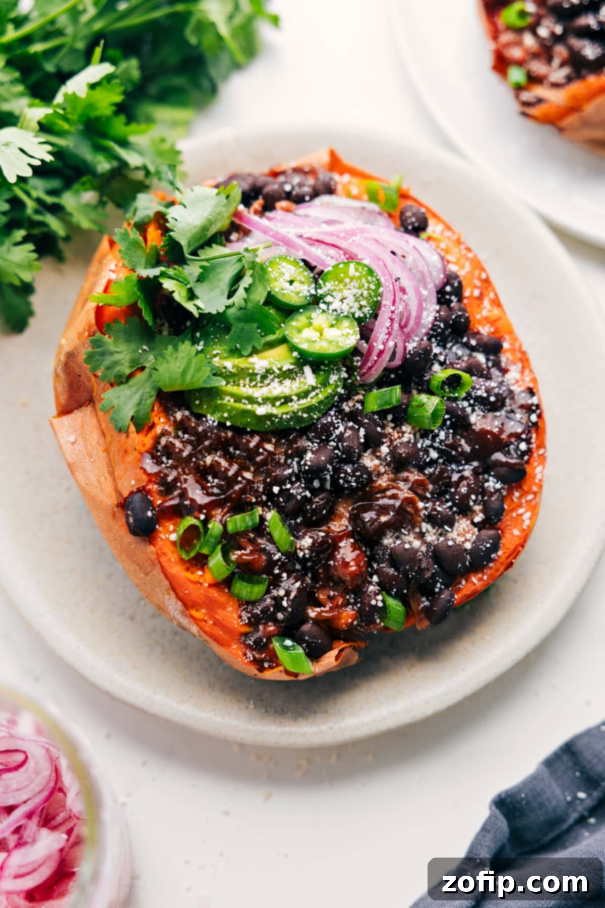 Loaded BBQ Chicken Sweet Potatoes 2 Mouth-watering BBQ Chicken Sweet Potato with creamy avocado and tangy pickled red onions, perfect for a nutritious lunch or dinner.