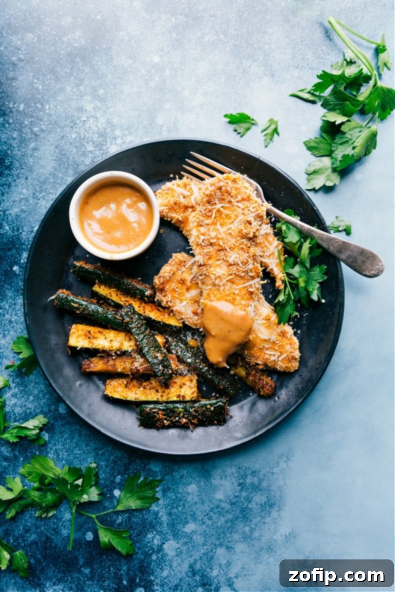A delicious serving of crispy Parmesan Sheet Pan Chicken and Zucchini on a plate, ready to be enjoyed.