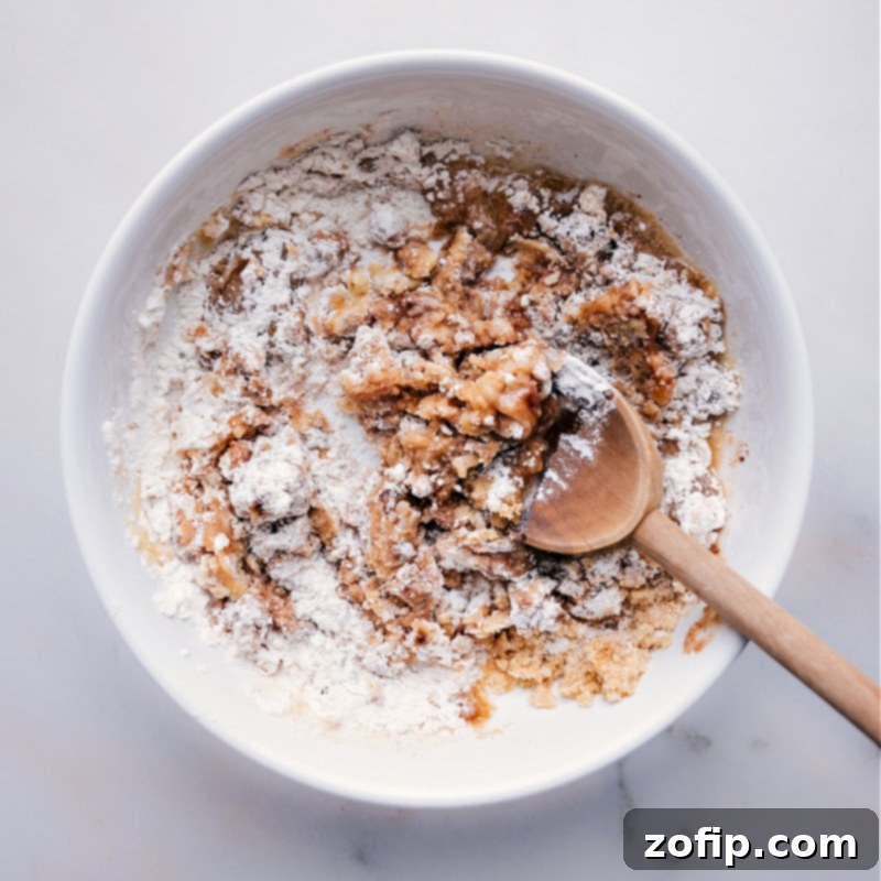 A crunchy, sweet, and buttery streusel topping can truly elevate any simple dessert. Discover our secret recipe for how to make streusel perfectly every time, adding a gourmet touch to your baked goods. Recipe via chelseasmessyapron. Ingredients for streusel being mixed together in a bowl, demonstrating the simple process of combining flour, sugar, and butter.