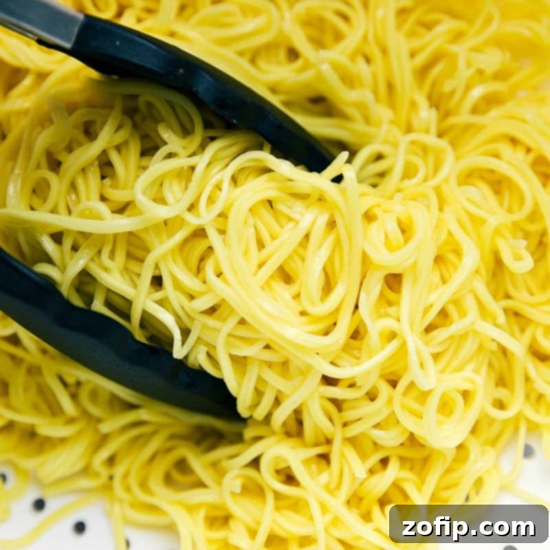 Perfectly cooked chow mein noodles, still steaming, waiting to be combined with the chicken and vegetables.