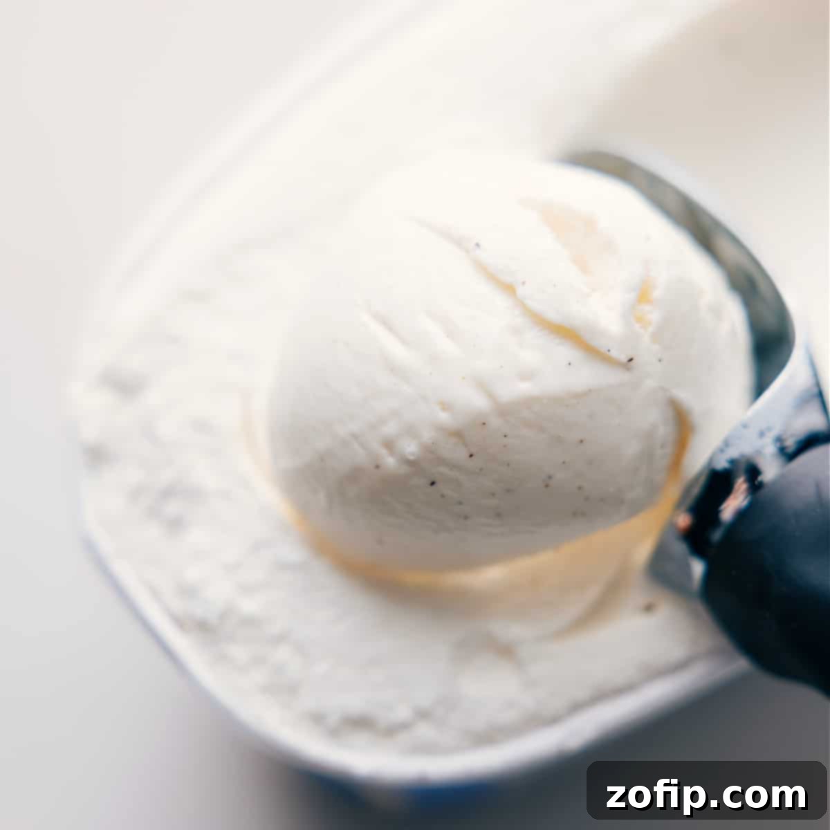 Scooping rich vanilla bean ice cream into a blender, the first step for a homemade Shamrock Shake.