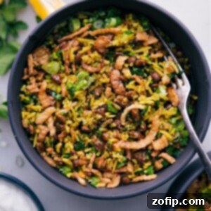 Close-up of a serving of Mujadara with golden caramelized onions, fresh parsley, and a lemon wedge.