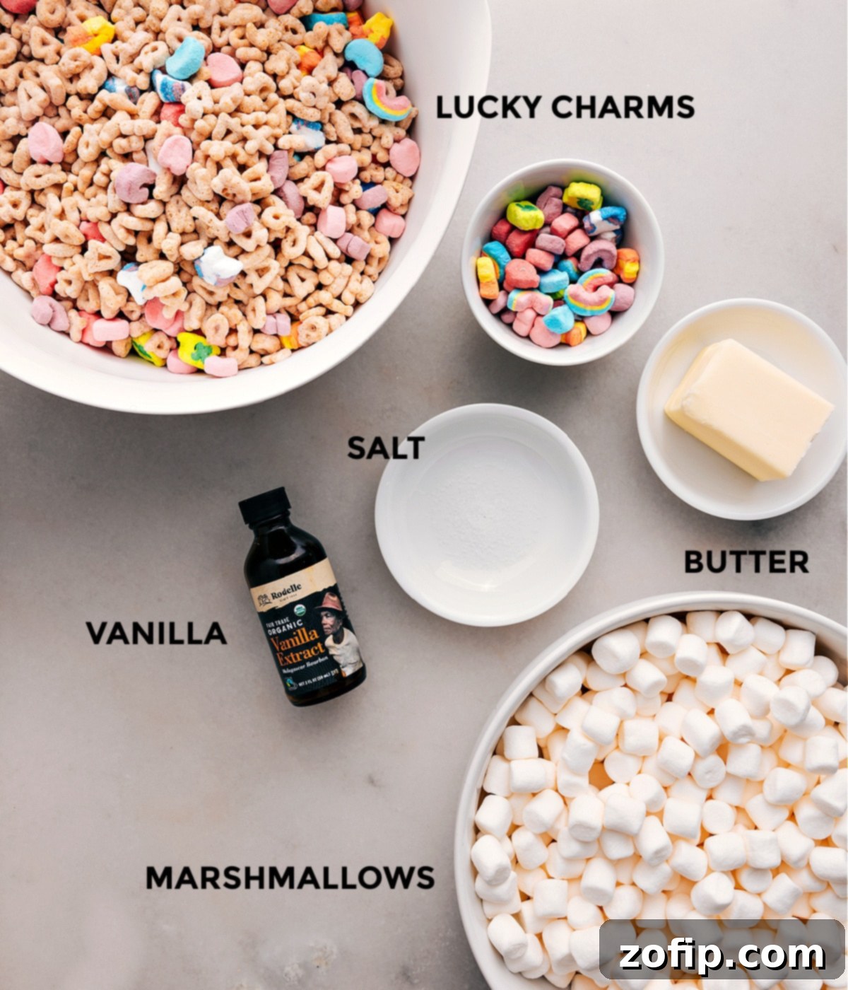 All the essential ingredients for Lucky Charms Bars laid out: cereal, butter, salt, vanilla extract, and miniature marshmallows.