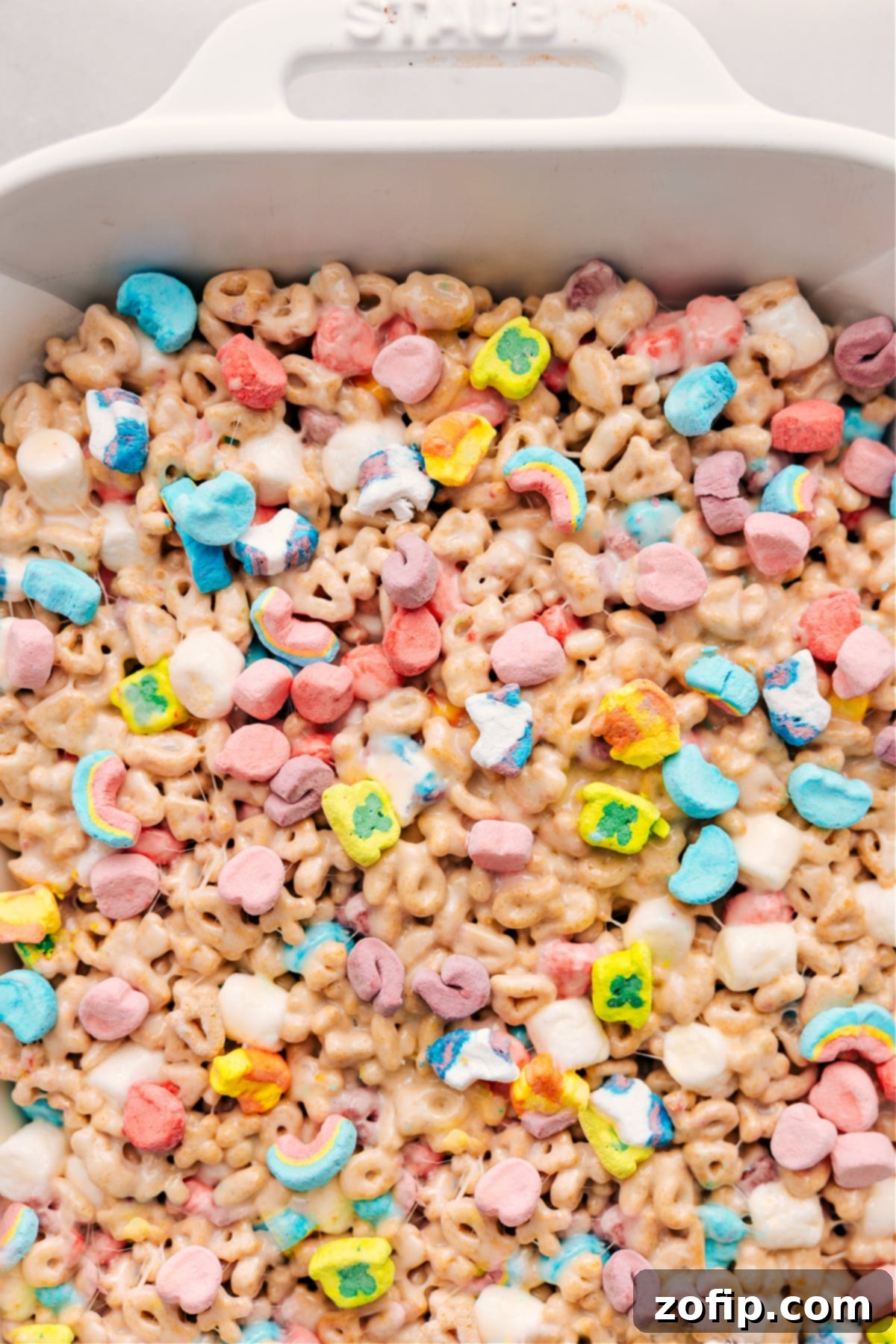 Lucky Charms Bars neatly arranged in a baking pan, ready to be cut, served, and enjoyed as a festive St. Patrick's Day treat.