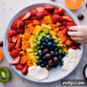 A vibrant Fruit Rainbow Tray with a cloud-like creamy dip, showcasing a perfect edible rainbow arrangement of fresh fruits.