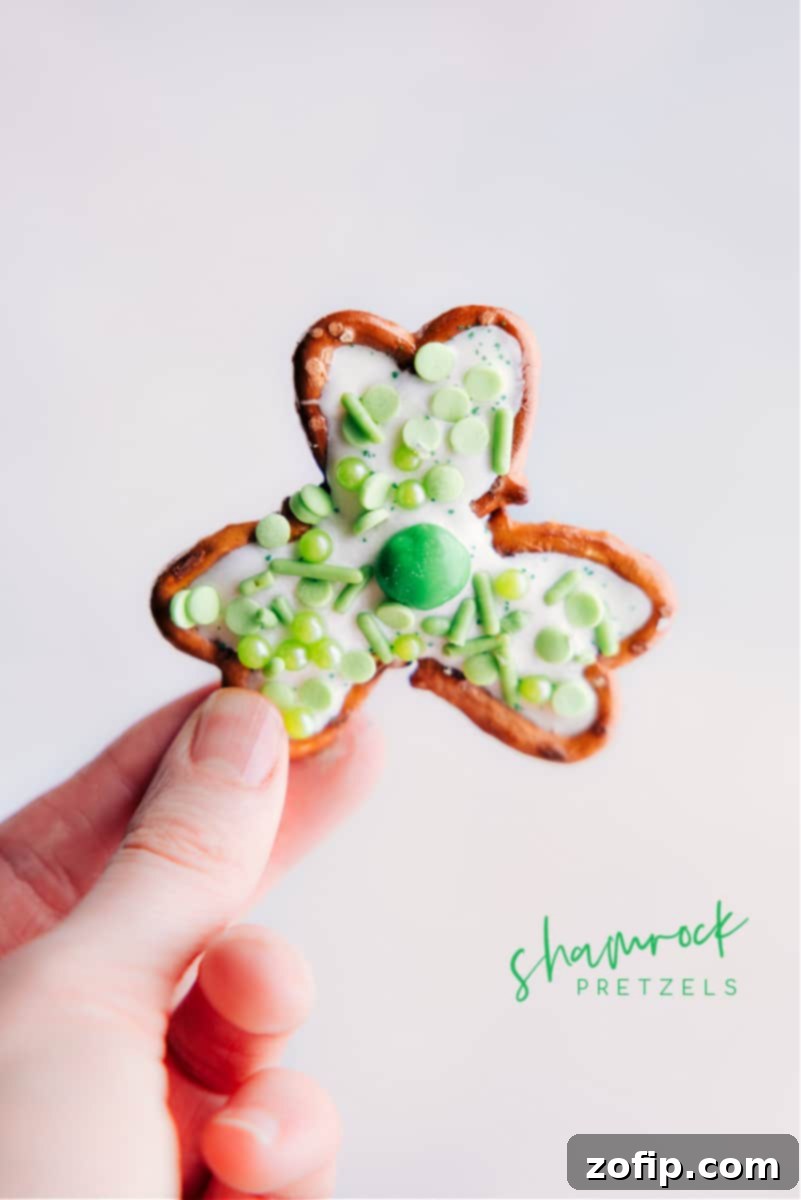 Lucky Pretzel Clovers 2 A hand holding up a freshly made Pretzel Shamrock, showing its vibrant green decorations.
