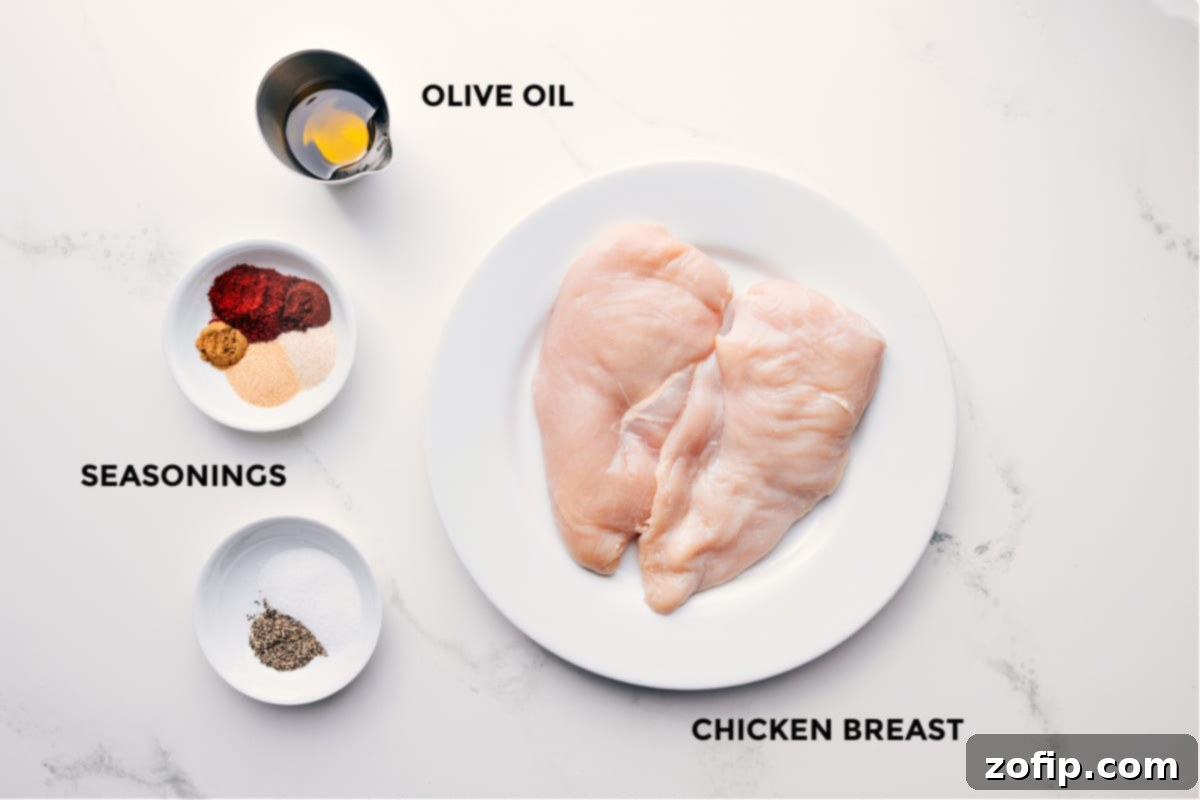 Collection of fresh ingredients for baked chicken breast including olive oil, various spices, and raw chicken fillets.