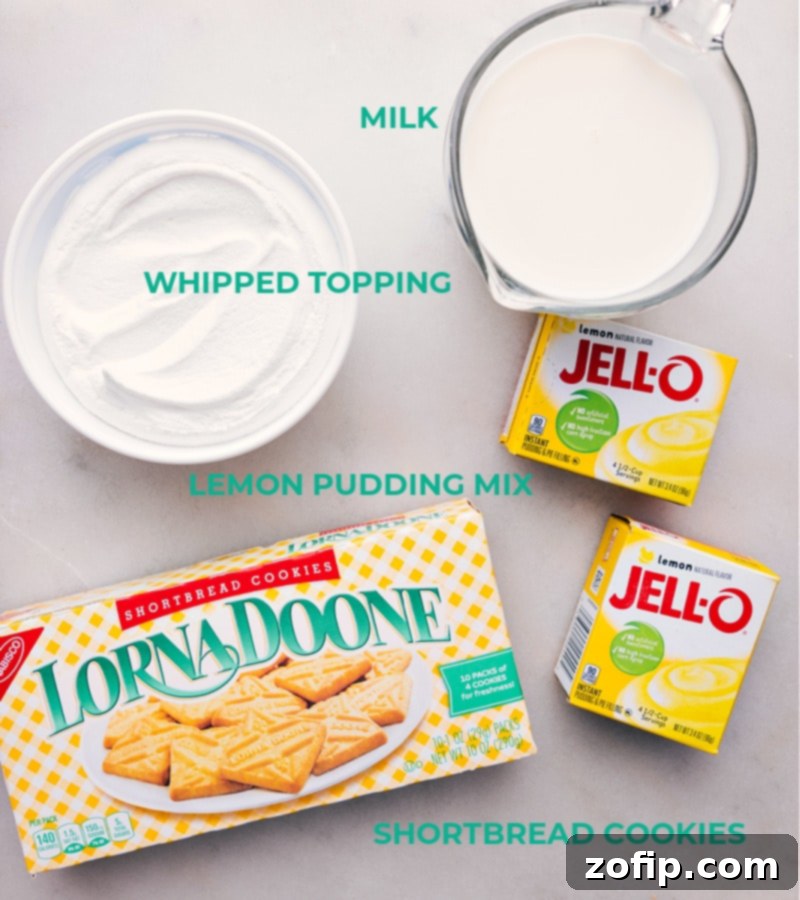 All ingredients laid out for Lemon Icebox Cake, including shortbread cookies, lemon pudding mix, milk, whipped topping, and a fresh lemon.