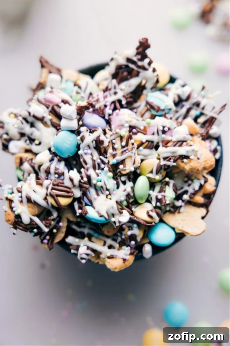Hoppy Easter Snack Blend 2 A beautifully arranged overhead image of the Easter Snack Mix in a decorative bowl, showcasing bunny grahams, pastel M&M's, marshmallows, and chocolate drizzle.