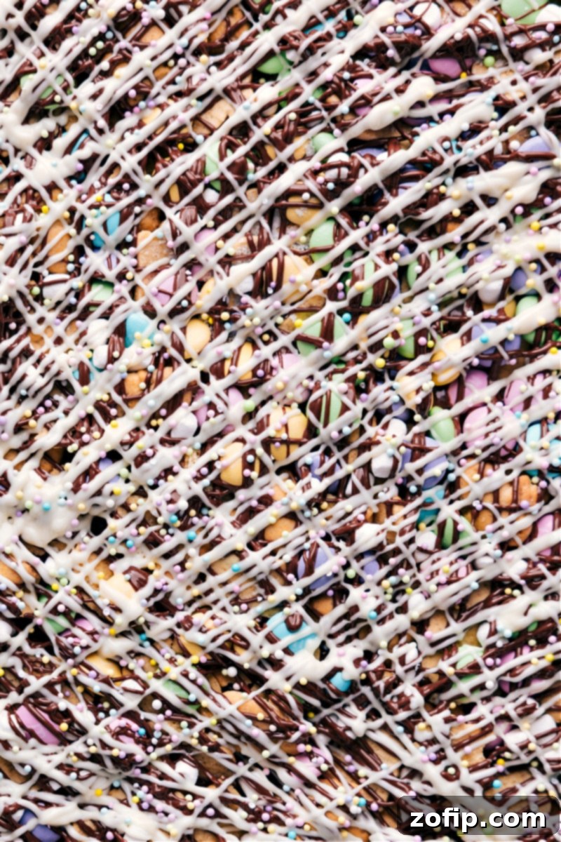 Hoppy Easter Snack Blend 6 A vibrant, close-up overhead shot of the finished Easter Snack Mix, showcasing the various textures and colors of bunny grahams, M&M's, marshmallows, and chocolate with festive sprinkles.