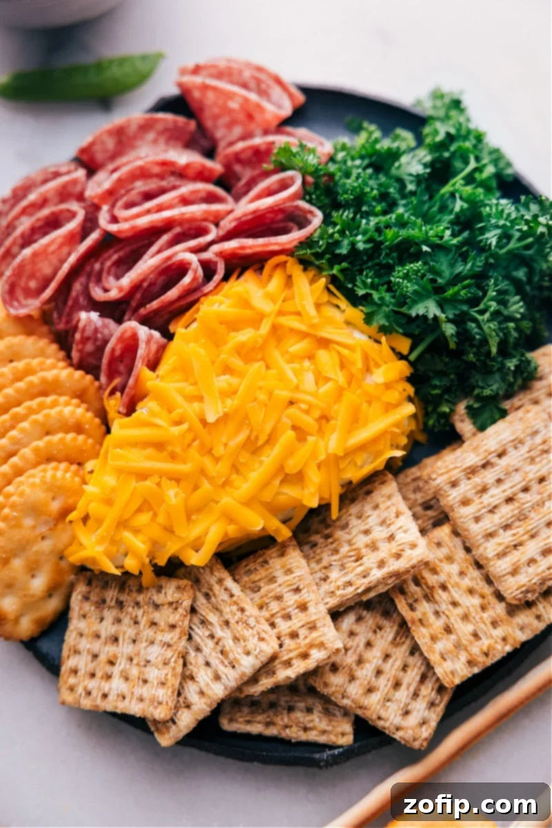 Overhead image of the vibrant Carrot Cheeseball, beautifully garnished with fresh curly parsley, ready to be served with an assortment of crackers and various fresh vegetables on a rustic wooden board.