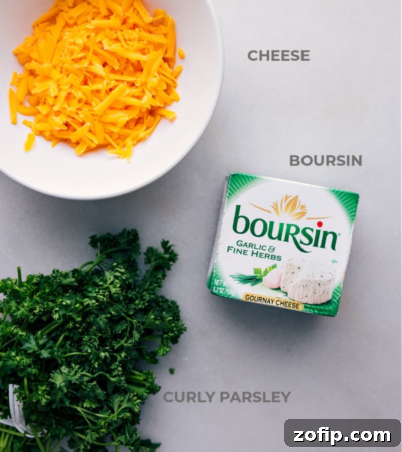 Close-up image showcasing the essential ingredients for the Carrot Cheeseball: a package of creamy Boursin cheese, a block of rich sharp Cheddar cheese, and a vibrant bunch of fresh curly parsley.