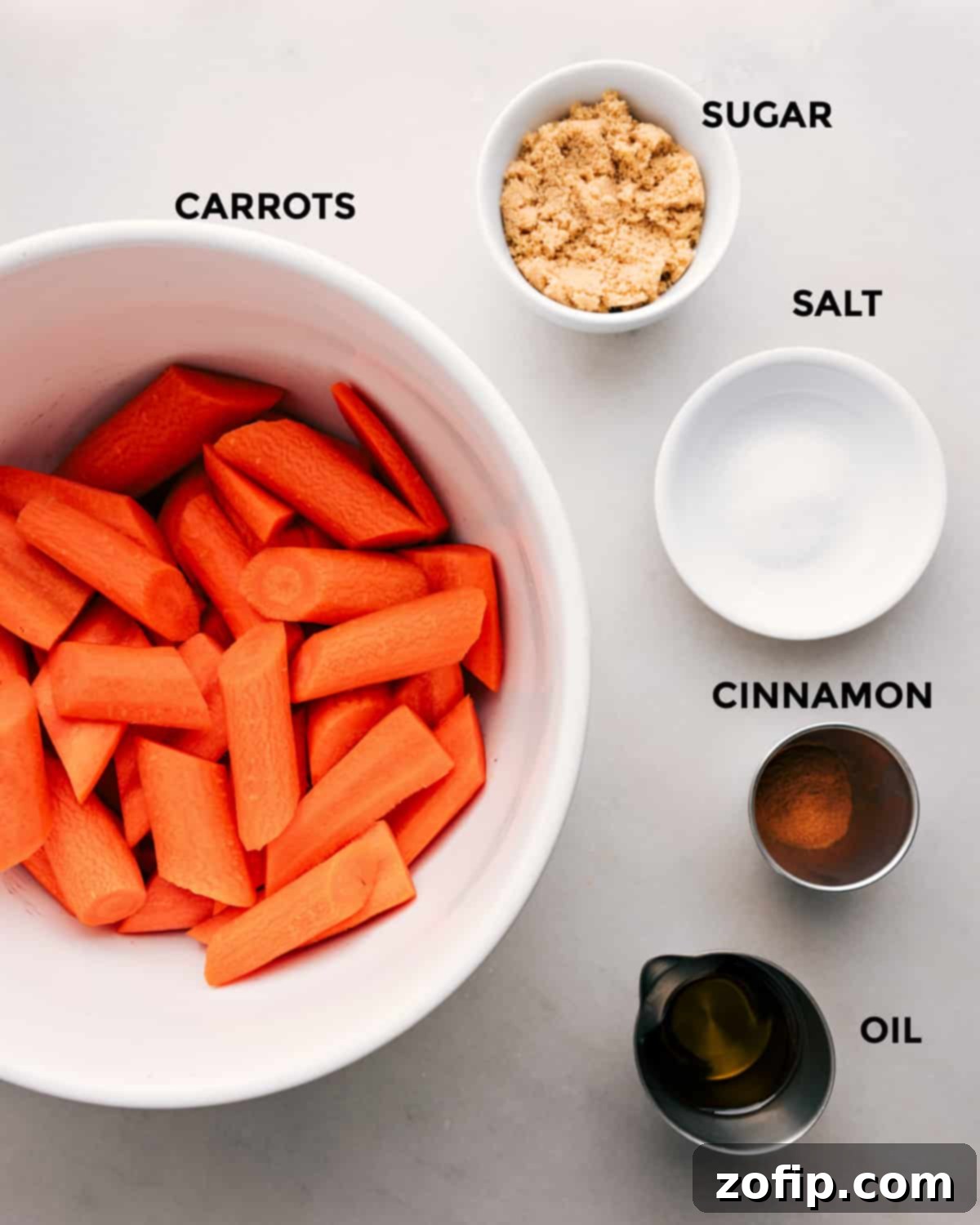 Simple Ingredients for Delicious Brown Sugar Roasted Carrots Ingredients for brown sugar roasted carrots laid out, including fresh carrots, brown sugar, cinnamon, olive oil, salt, and pepper.