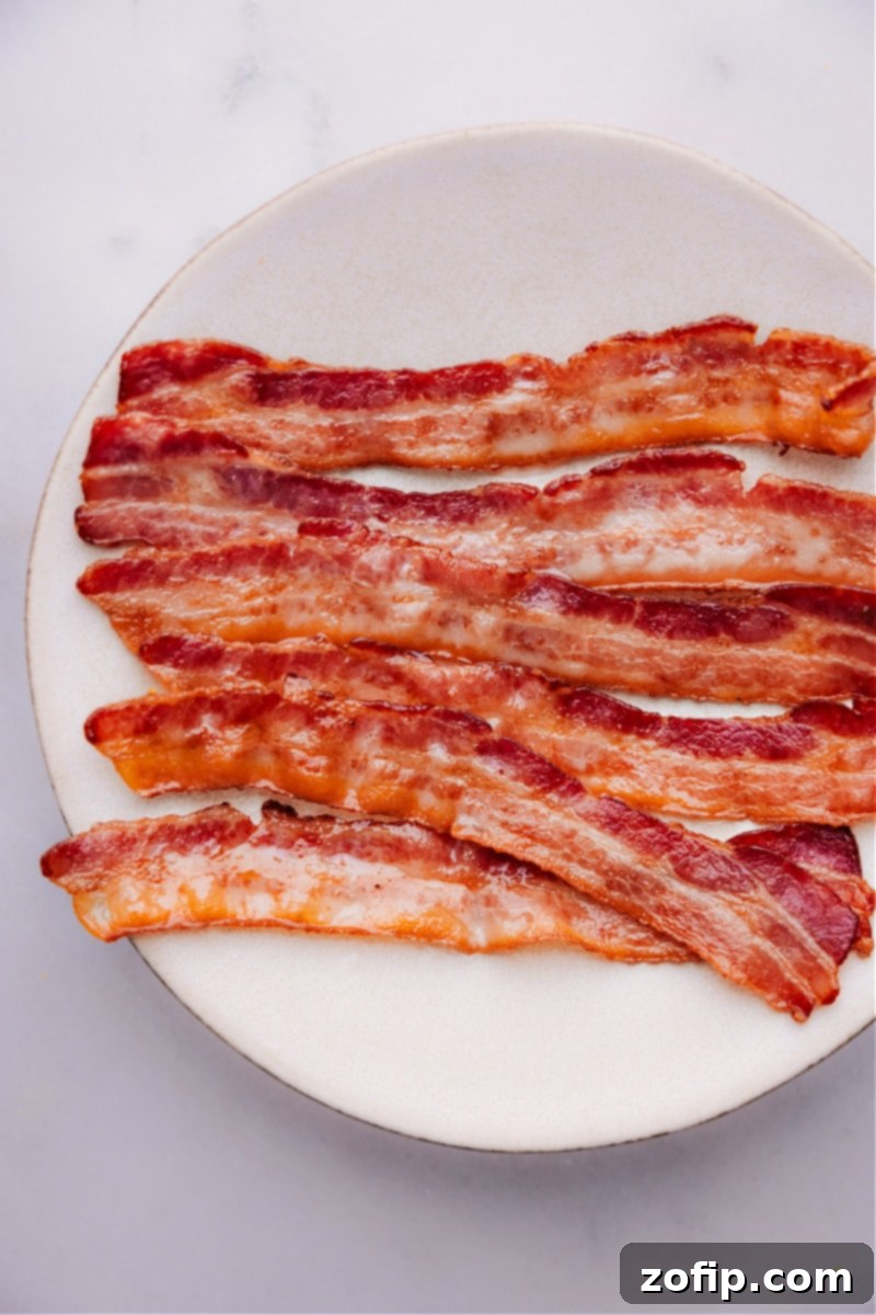 Overhead image of a complete breakfast plate featuring perfectly baked bacon