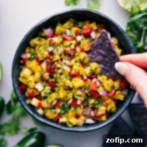 A top-down view of vibrant pineapple salsa in a small white bowl.