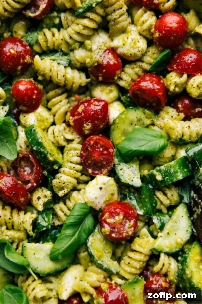 Up-close overhead image of Pesto Pasta Salad in a large serving bowl, showing its fresh ingredients and creamy texture, making it the perfect side dish for any meal or gathering.