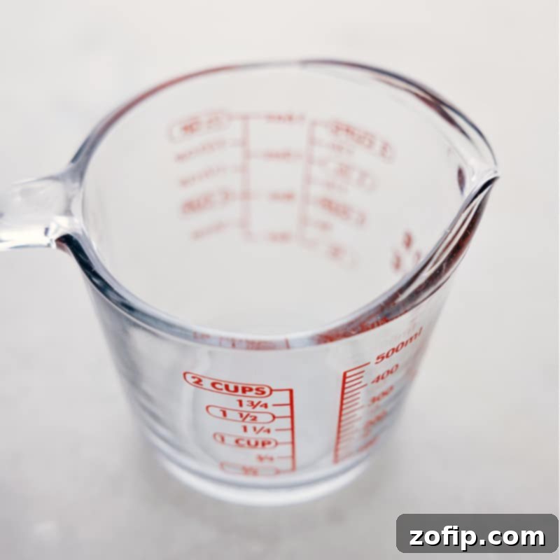 Image of a glass liquid measuring cup, partially filled, illustrating correct eye-level reading for accurate measurement in the kitchen