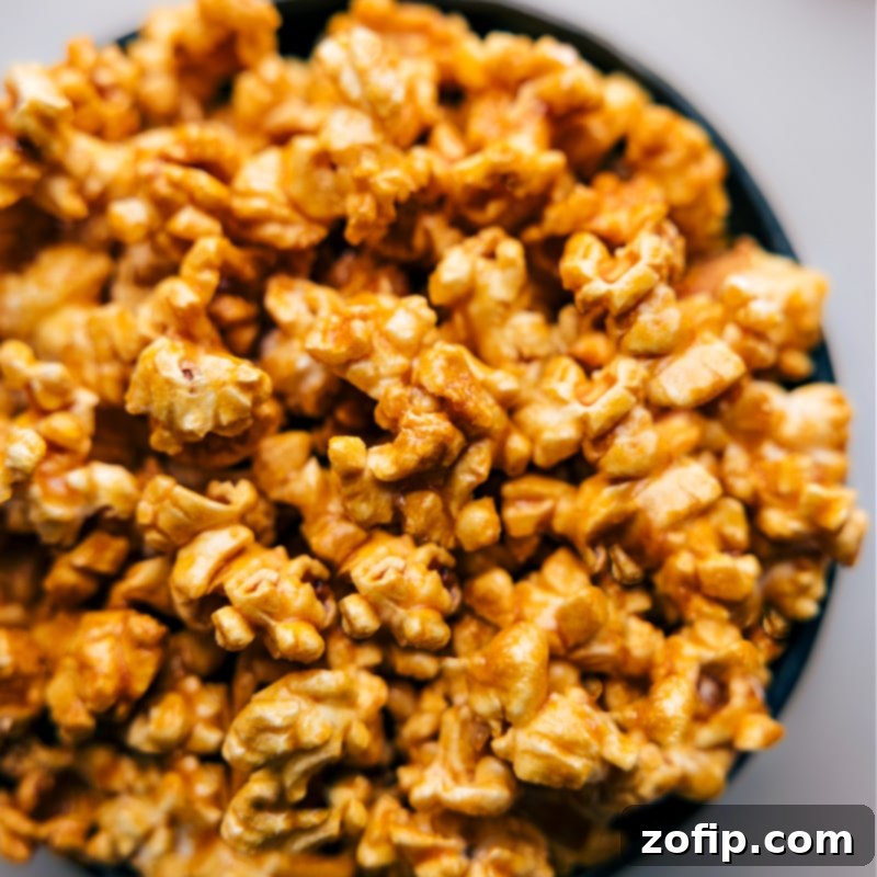 Up-close overhead view of finished Microwave Caramel Corn, ready for serving in a bowl, showing its glossy coating and inviting texture.